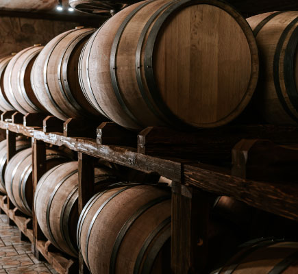 Oak barrels aging wine in cellar